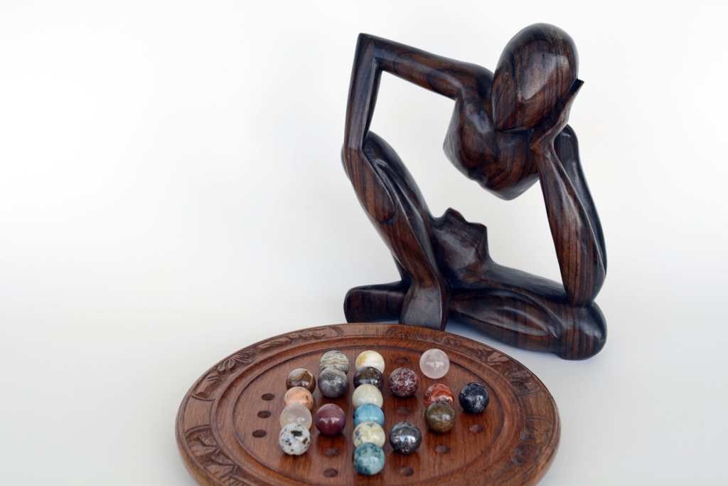 Abstract wooden sculpture gazing at marbles, symbolizing the debunking of business development myths.