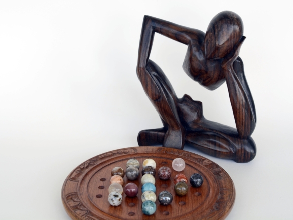 Abstract wooden sculpture gazing at marbles, symbolizing the debunking of business development myths.