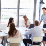 Group of professionals brainstorming in an office, strategizing to gain a competitive edge in real estate.