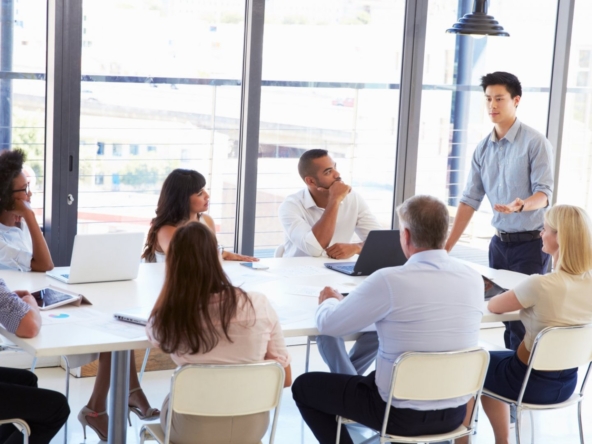 Group of professionals brainstorming in an office, strategizing to gain a competitive edge in real estate.